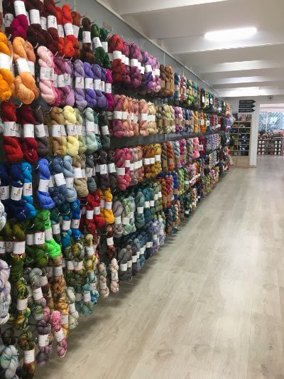 View of the wall of the shop full of hand-dyed yarn skeins